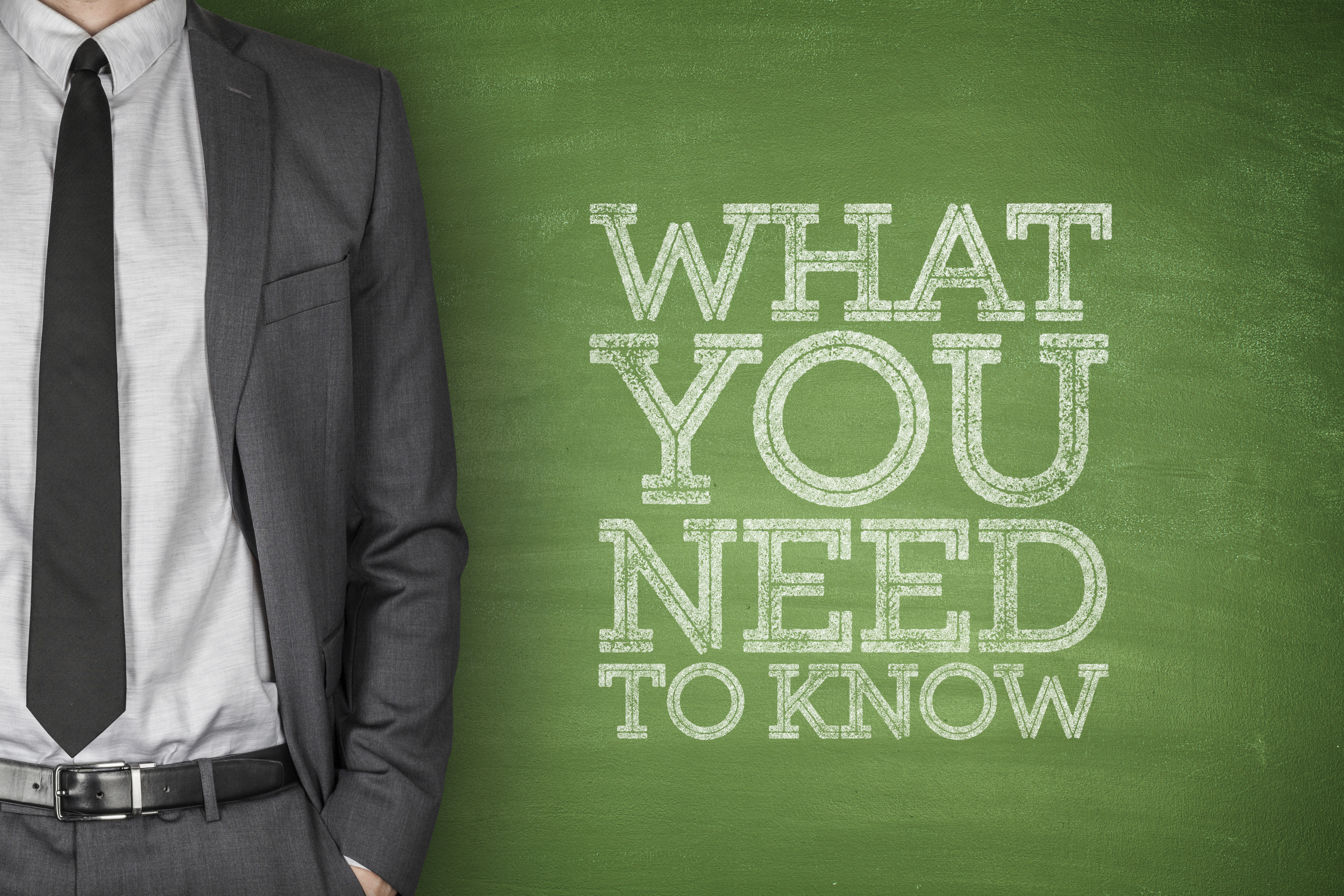 A person standing next to a board  where it's written: What You need to Know